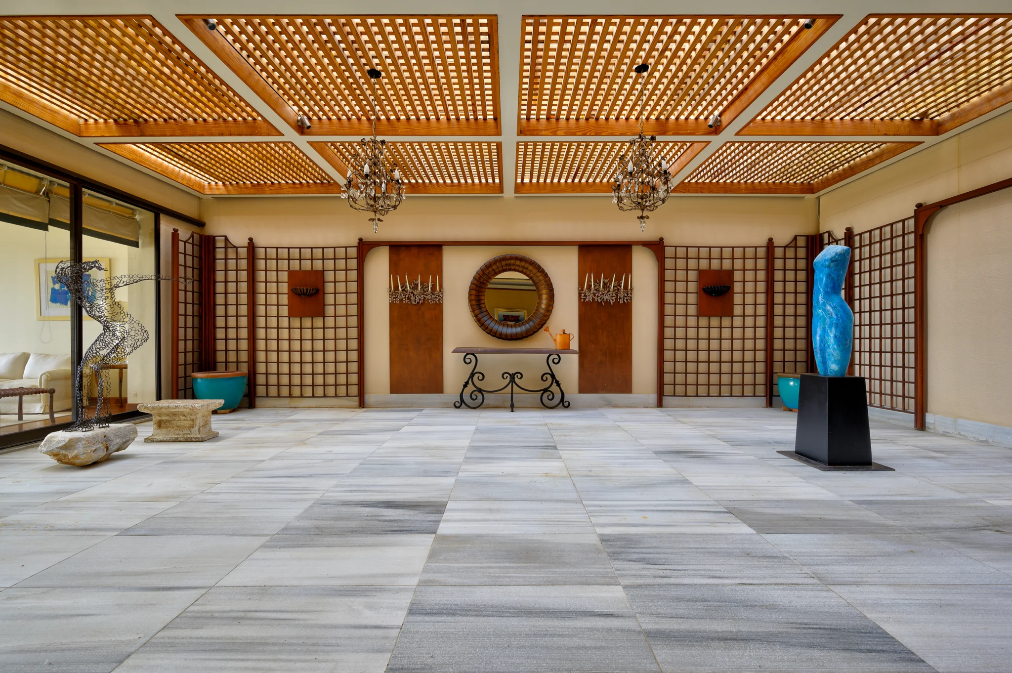 Sculptures and chandeliers beneath a timber lattice ceiling at Villa Icarus.