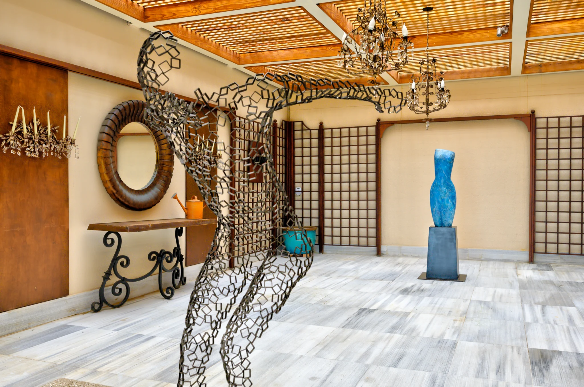 Figurative metal sculpture beneath a lattice ceiling at Villa Icarus.