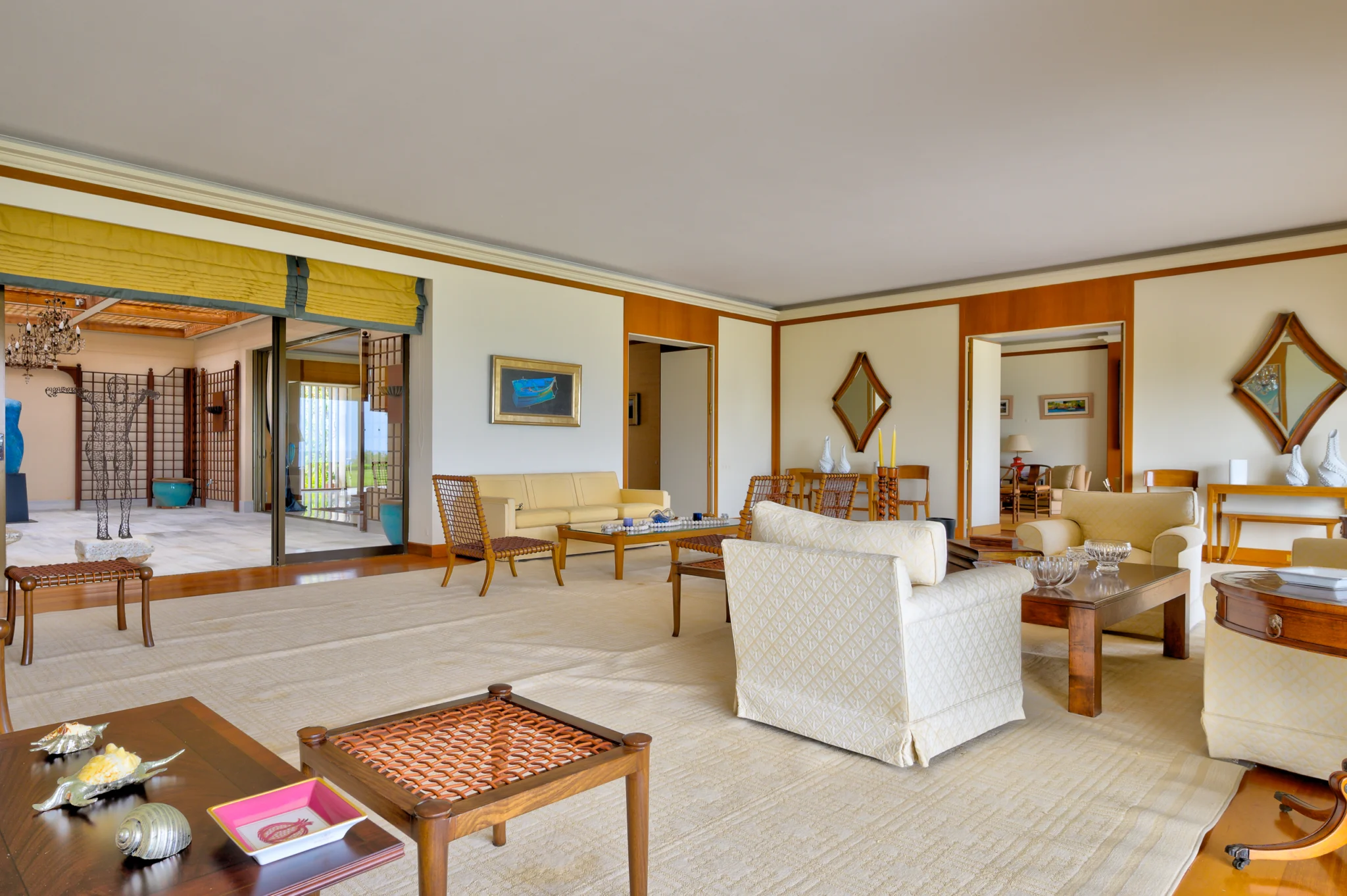 Living room with pale upholstered seating and warm-toned wall panels at Villa Icarus.