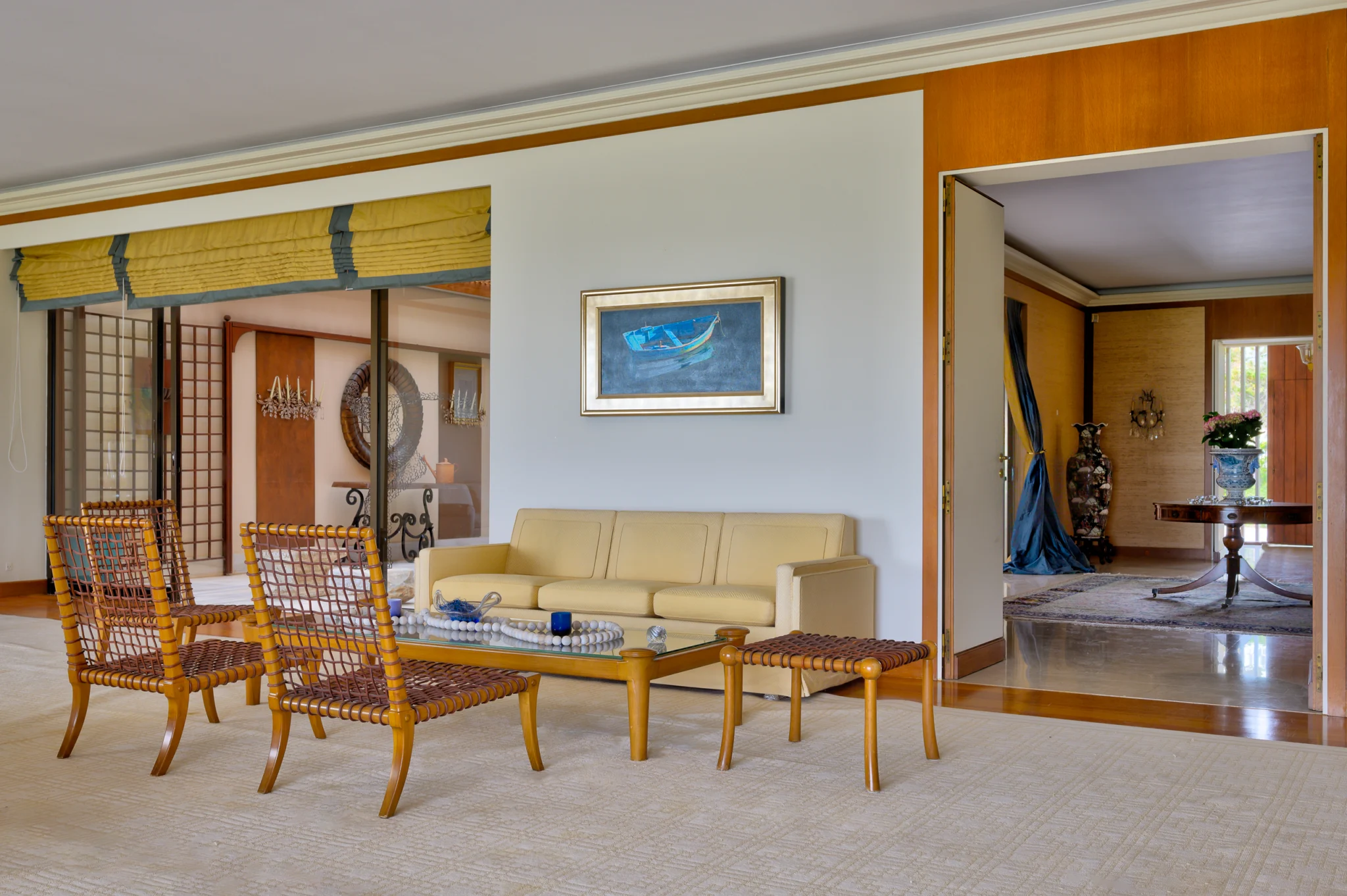 Sitting area with patterned chairs, a cream sofa and framed artwork at Villa Icarus.