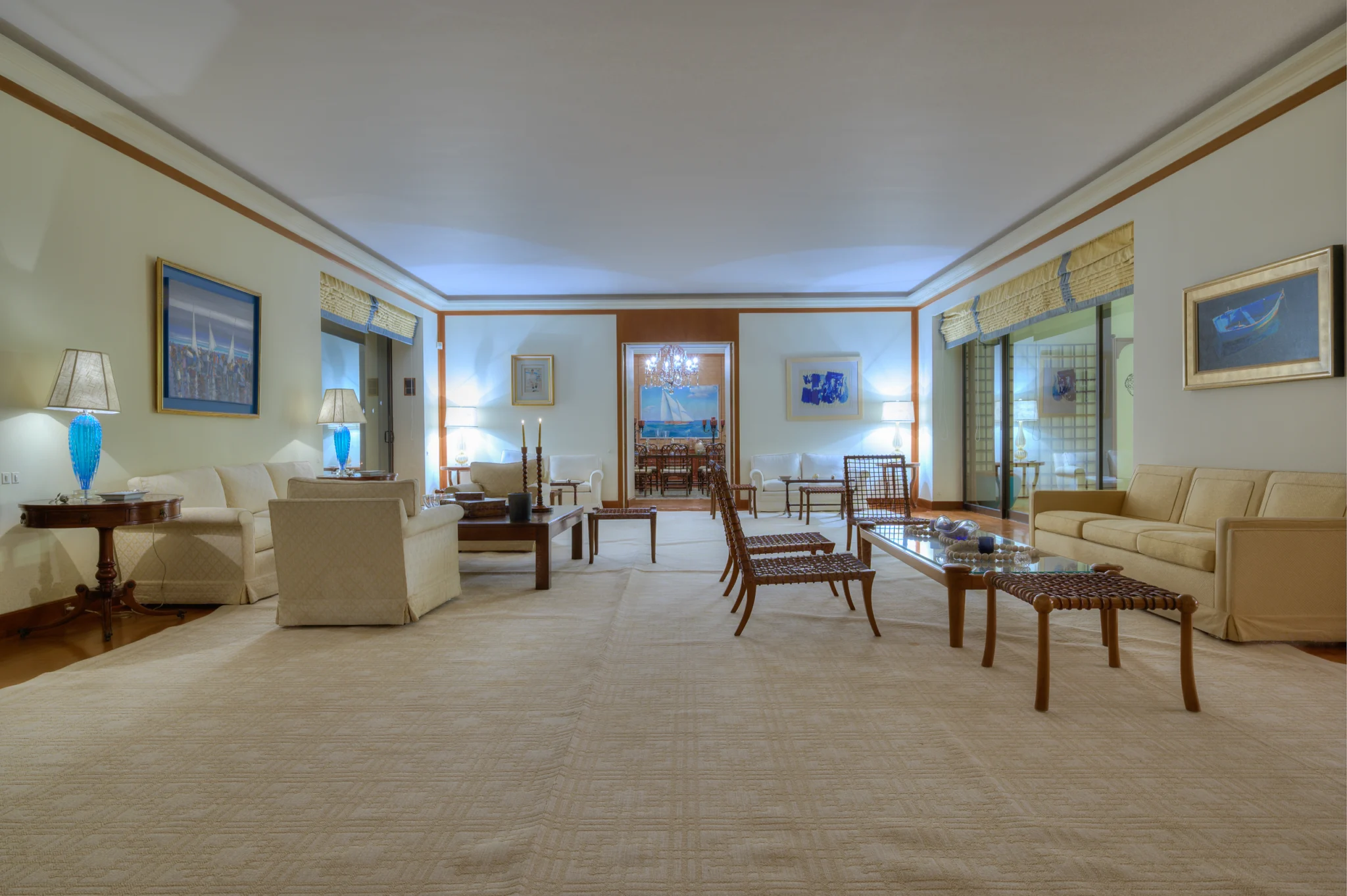 Living room with pale seating, framed artwork and patterned chairs at Villa Icarus.
