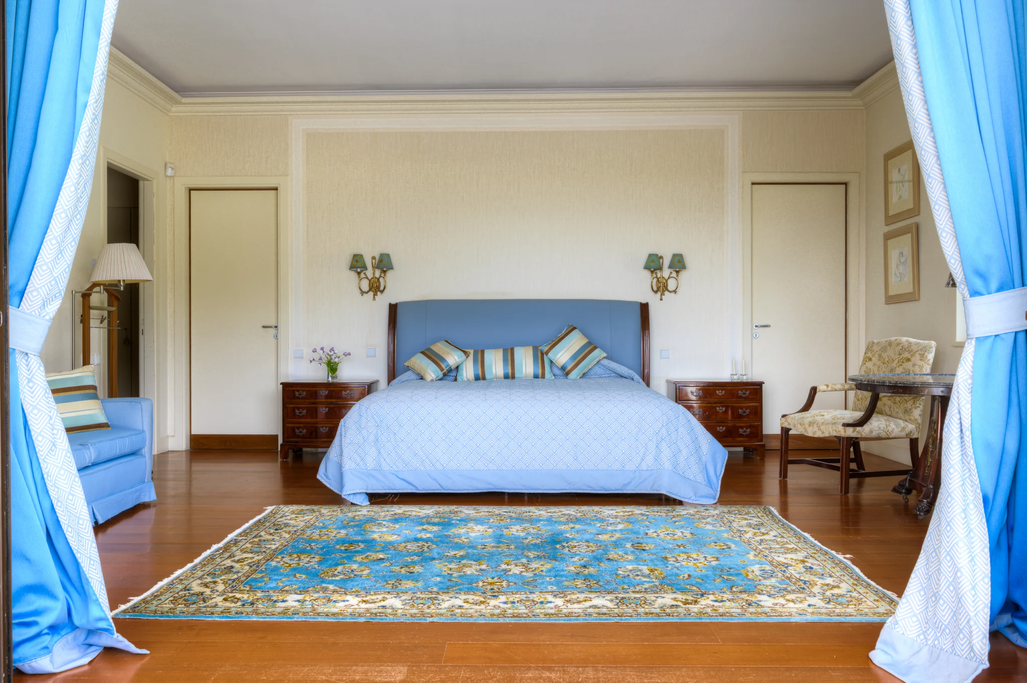 Blue bedroom framed by open curtains at Villa Icarus.