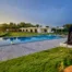 Swimming pool, lawn and villa in warm evening light at Villa Icarus.