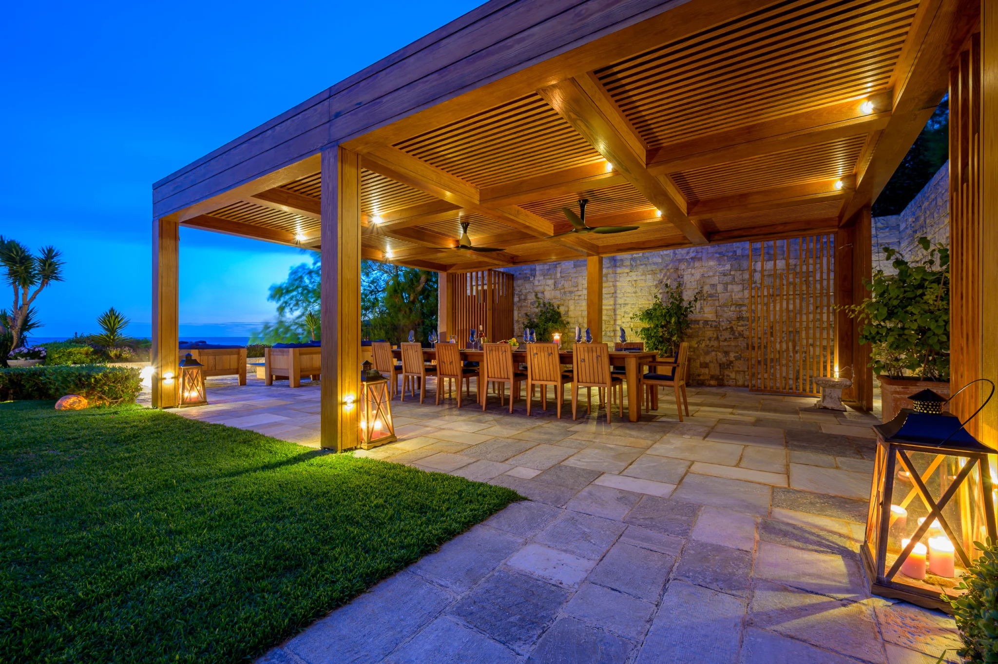 Illuminated timber pergola and dining terrace at blue hour at Villa Icarus.