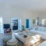White sofa with striped cushions and turquoise doors framing the sea at Villa Salvia, Paros.