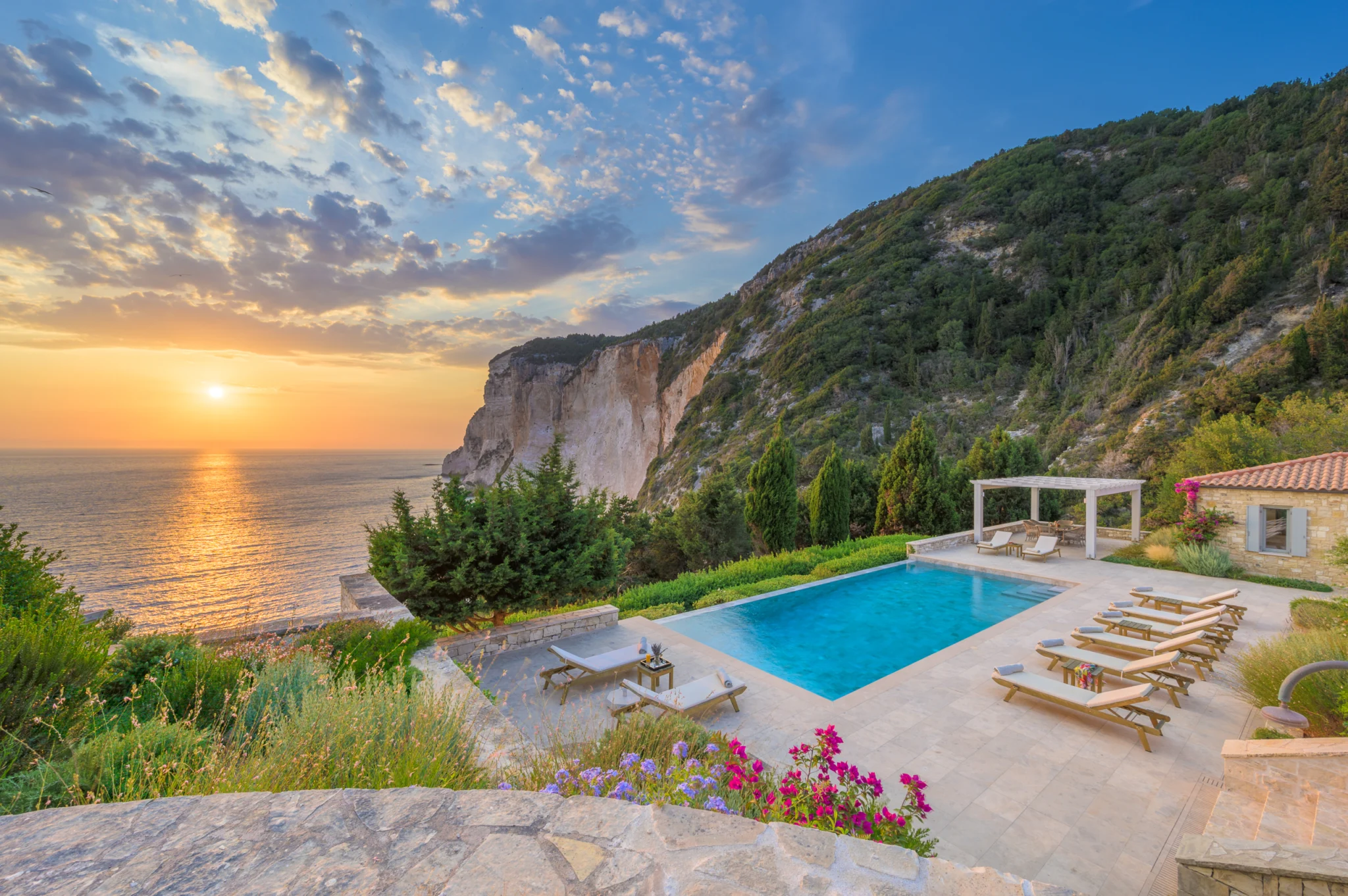 Swimming pool and coastal cliffs at sunset at Villa Sargasso, Paxos.