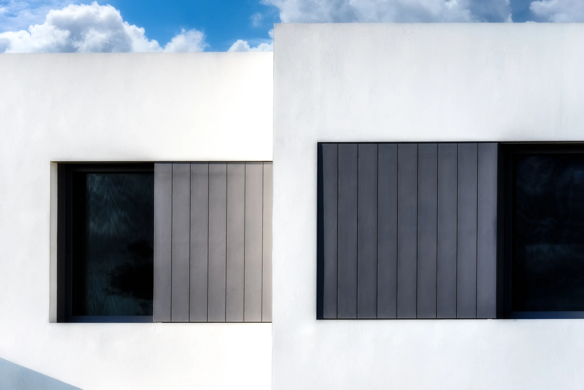 White facade detail with grey timber shutters at Villa Seafront, Paros.