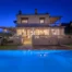 Illuminated stone villa and blue swimming pool at twilight at Villa Vicanti near Pylos, Peloponnese, Greece.