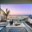 Balcony at dusk with a hanging chair, wine and a panoramic sea view at Zoe’s Sea View in Pylos, Greece.